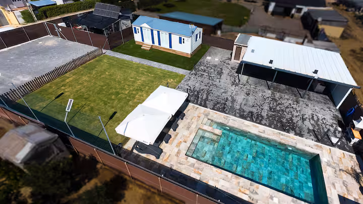 Vista de la piscina privada, jacuzzi y jardín de Villa Thiago